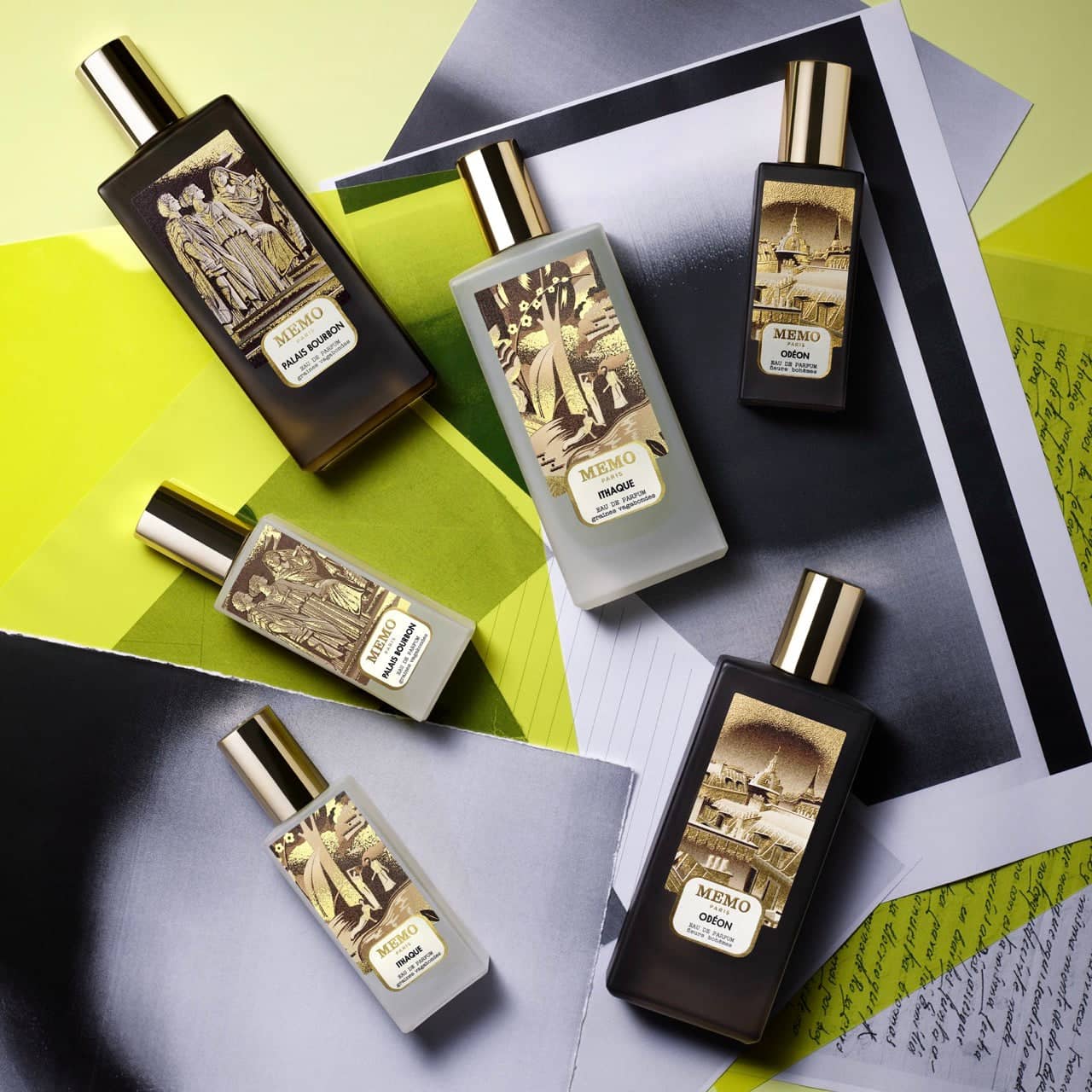 Five rectangular perfume bottles with gold caps and intricate golden illustrations on dark or translucent glass, featuring the memo paris brand.