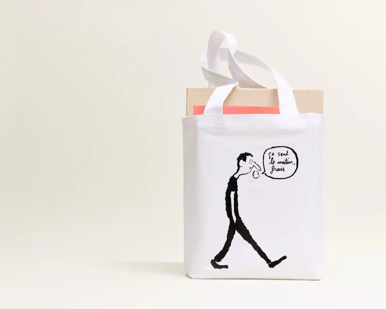 White canvas tote bag with a black cartoon drawing of a man walking.