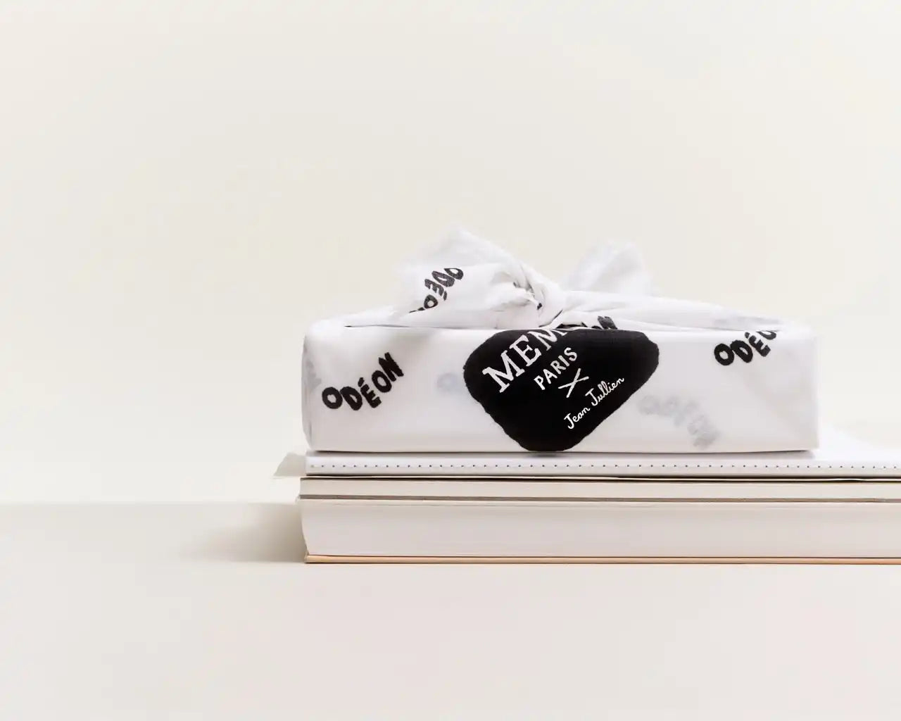 White gift-wrapped box with a black heart-shaped tag.