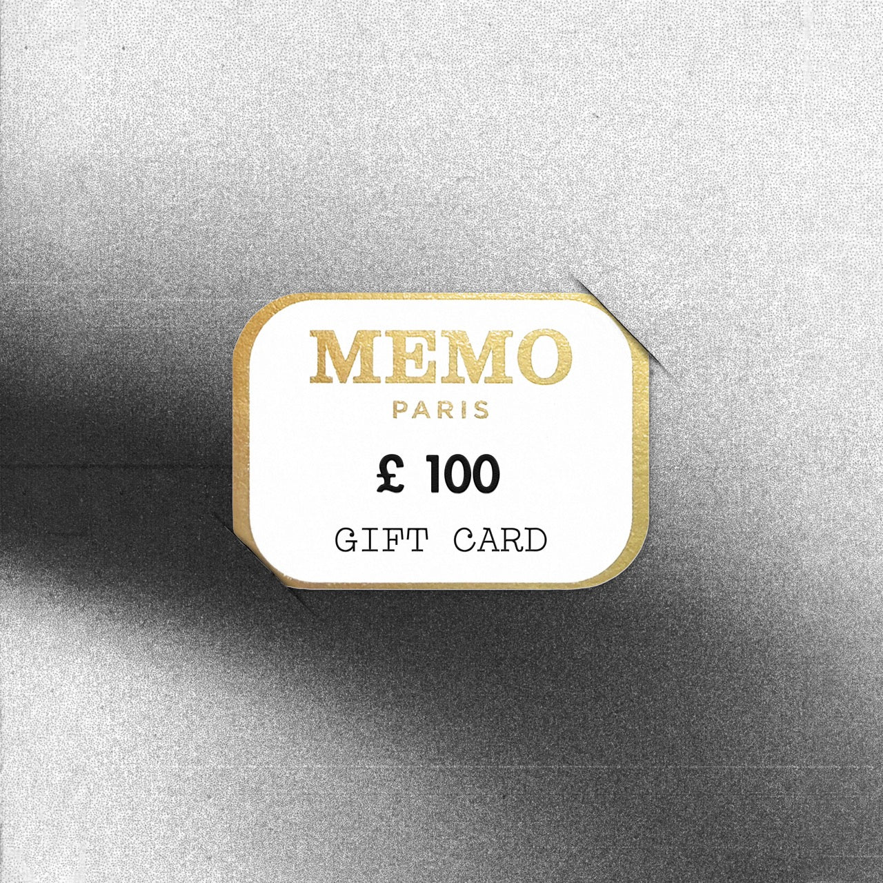 A white and gold memo paris gift card with a 100 dollar denomination celebrating dream destinations