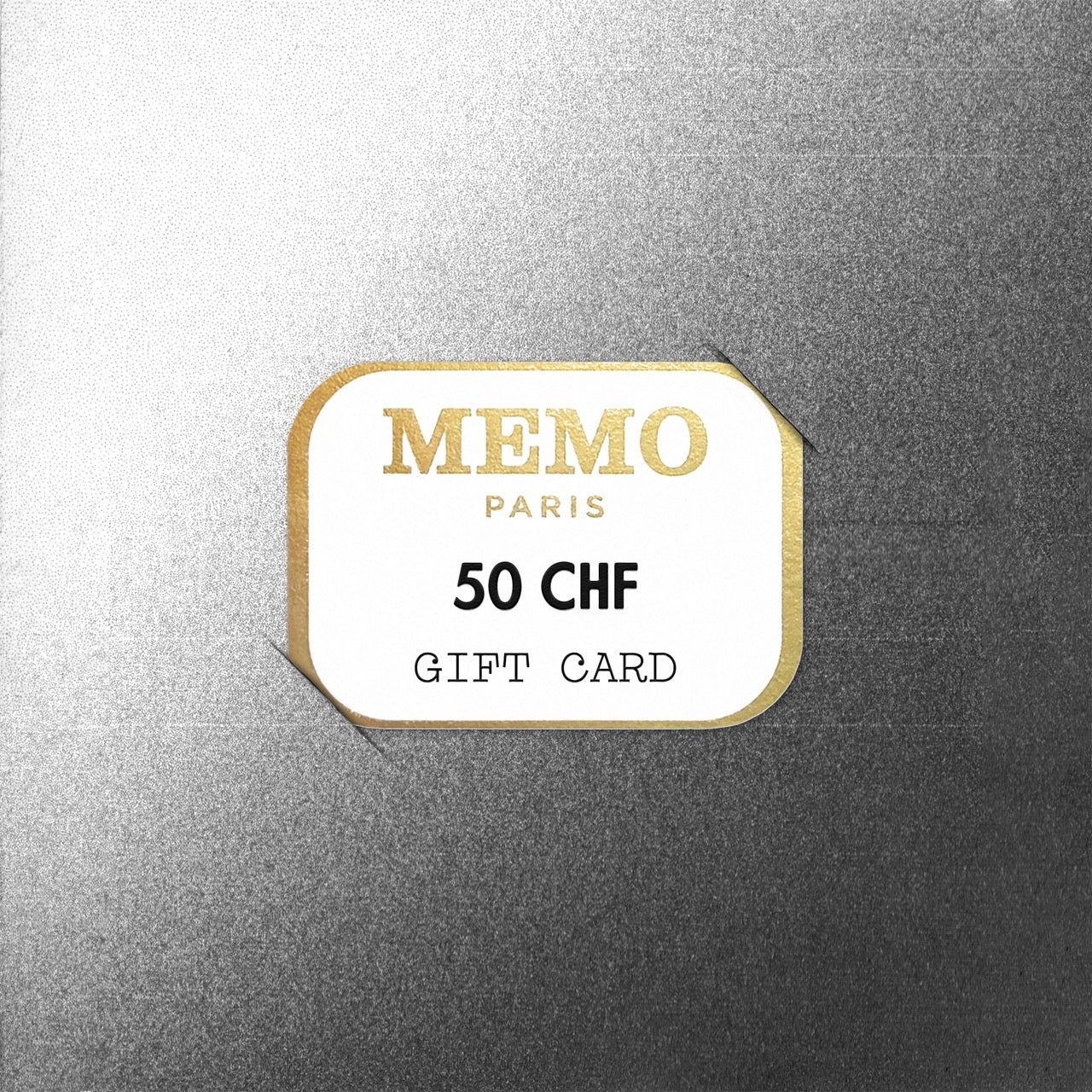 A white and gold memo paris gift card displaying 50 chf on a textured silver background celebrating dream destinations