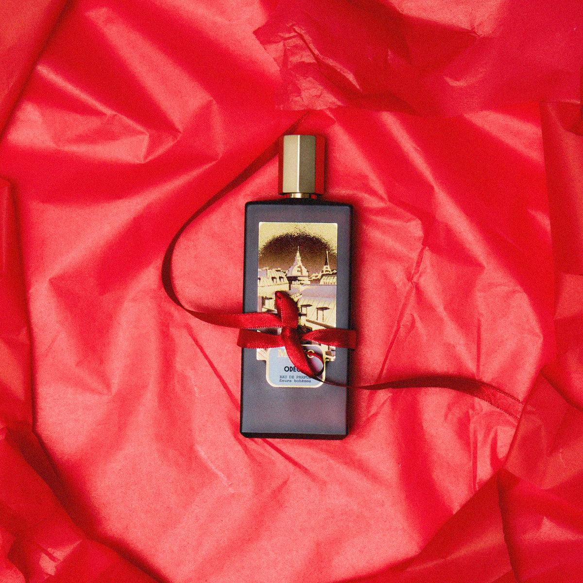 Odéon tied with a red ribbon on red tissue paper