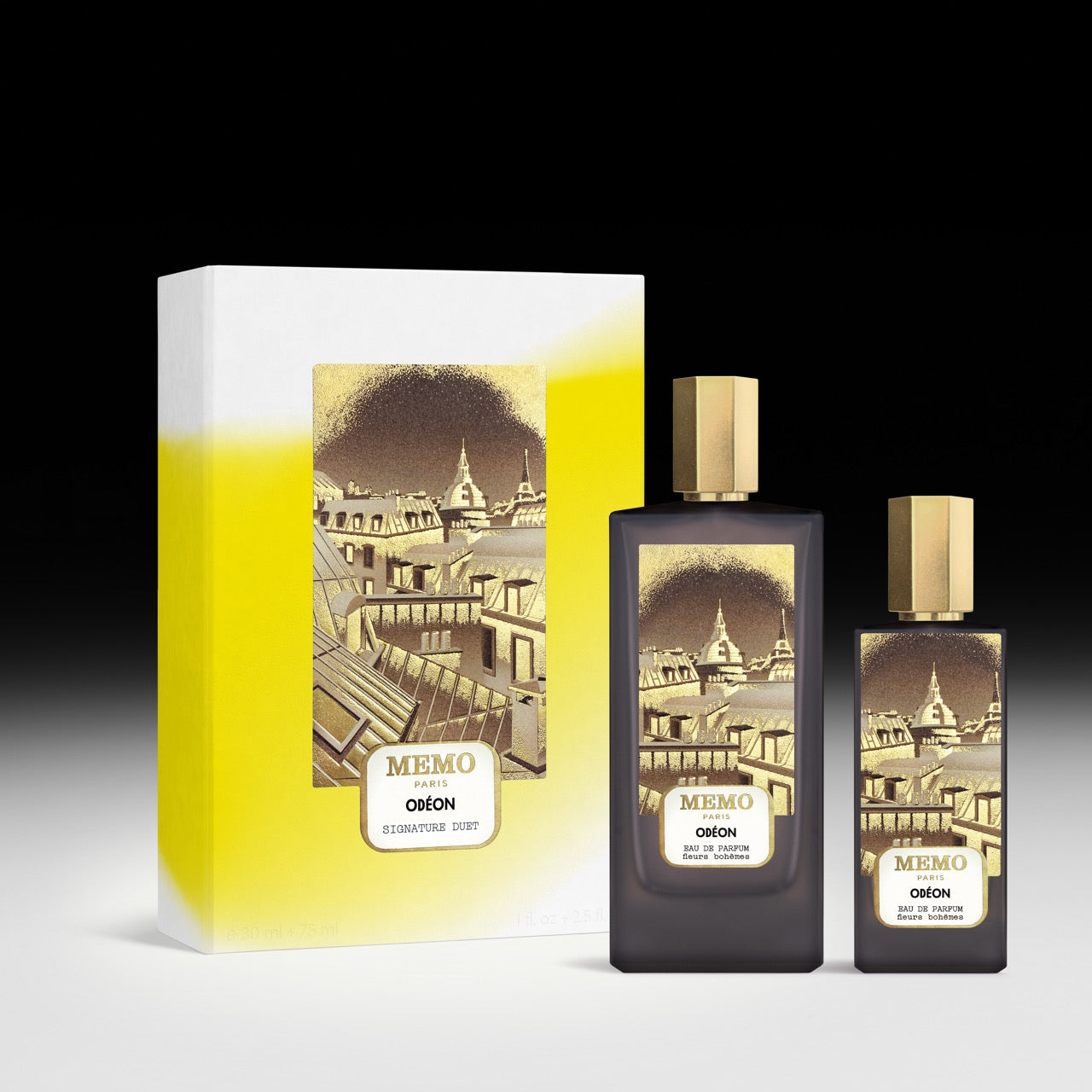 Dark glass signature duet odéon perfume bottles with gold caps and parisian skyline labels beside gradient box with tonka bean notes