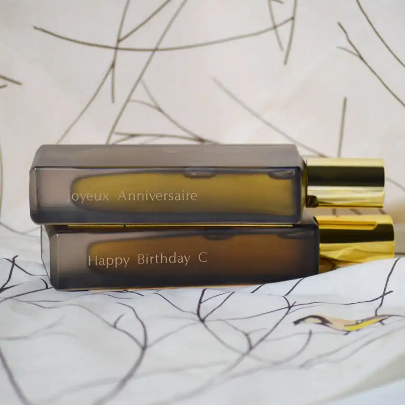 Two stacked, personalized perfume bottles.